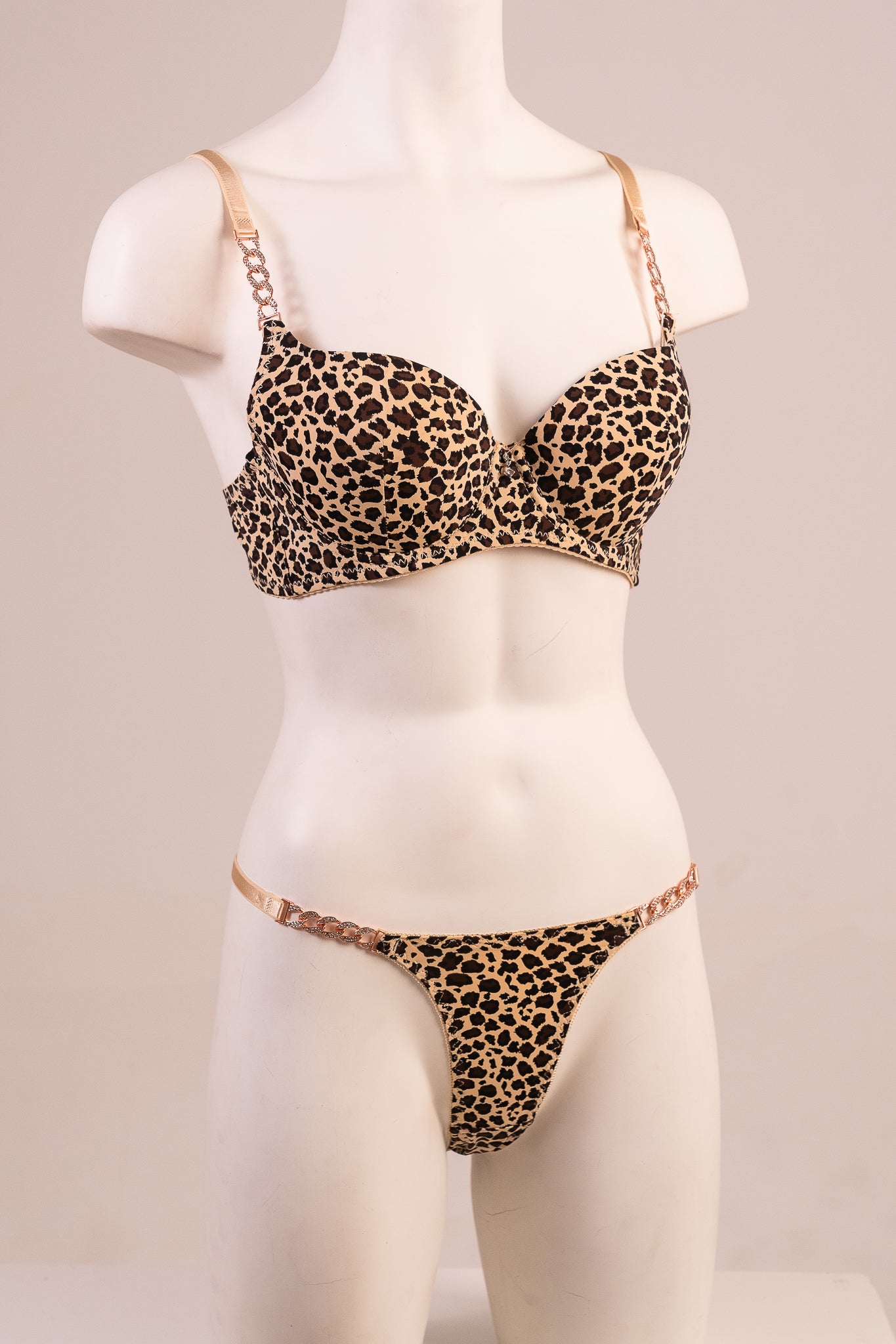 Leopard print bra and panties set on a mannequin against a plain background